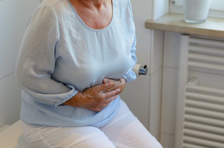 Senior woman sitting on toilet